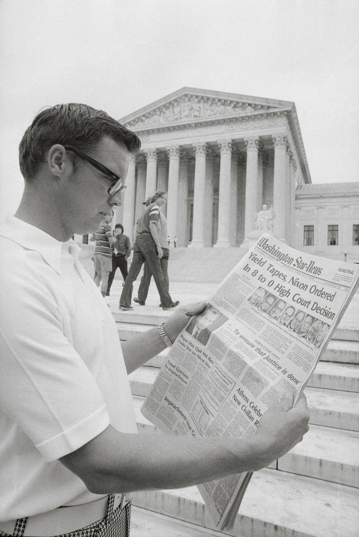 A visitor in the nation's capital reads the headlines in 1974 in front of the Supreme Court telling of the court's ruling ordering President Nixon to surrender 64 White House tape recordings. 