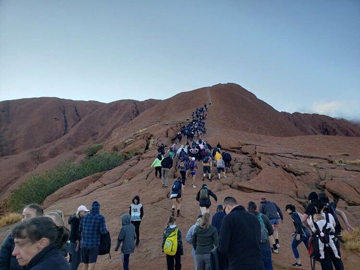 Tourists crowd a trail as they attempt to climb the Uluru