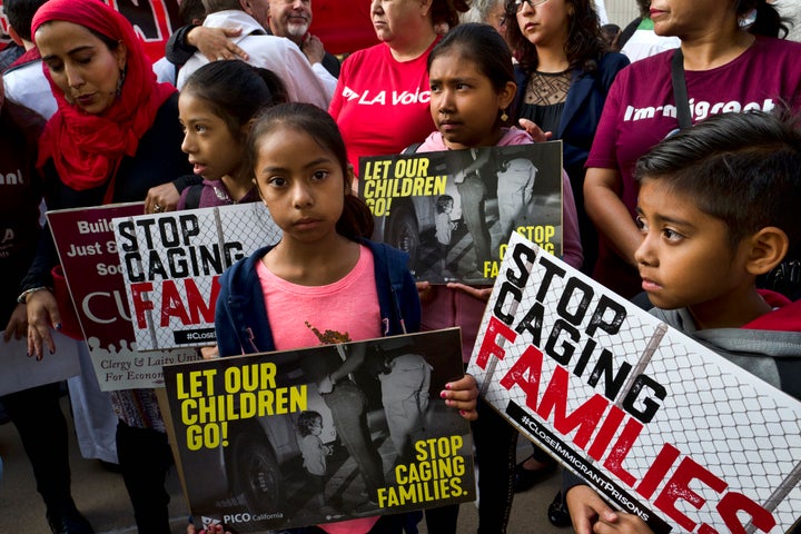 In this June 26, 2018, file photo, children stand and hold protest signs during a rally in front of Federal Courthouse in Los Angeles. (AP Photo/Richard Vogel, File)