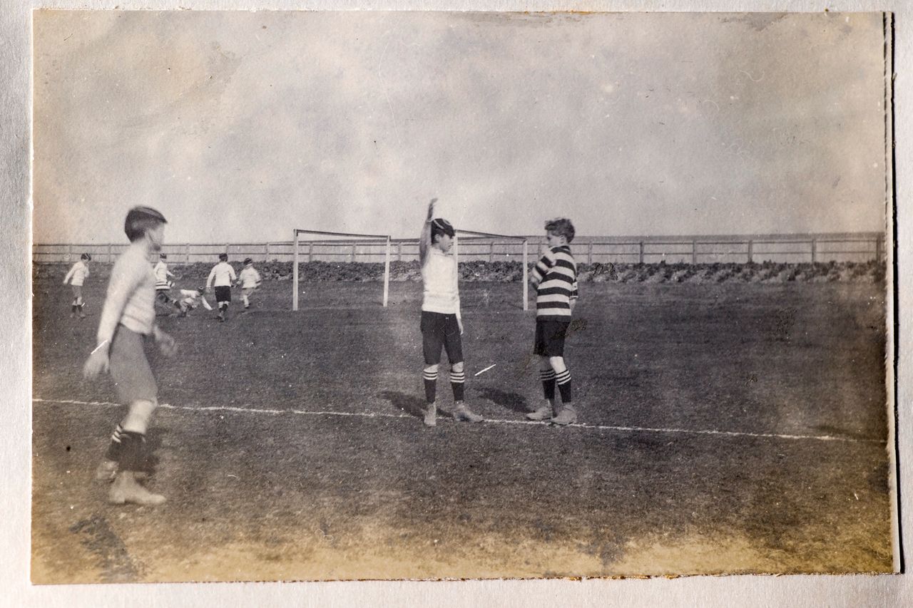 Vintage photograph of a group of boys playing football. From the late victorian or early edwardian period.