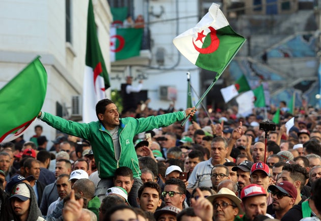 Demonstrators carry national flags during a protest against the country's ruling elite and rejecting...