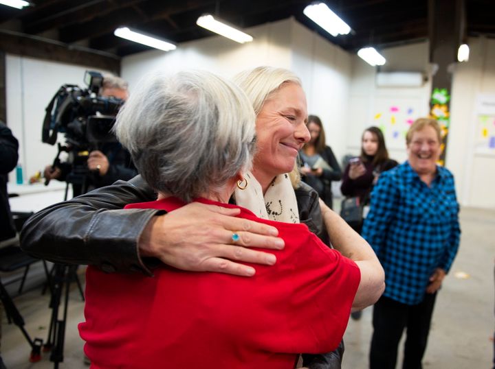 MP Catherine McKenna hugs a member of her team after speaking to reporters after a misogynistic slur was spray painted on her campaign office in Ottawa, on Thursday, Oct. 24, 2019.