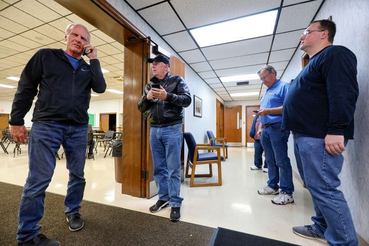 Officials of UAW Local 160 check their phones to get updates on the UAW-GM contract ratification vote count on Oct. 25, 2019 in Warren, Michigan.
