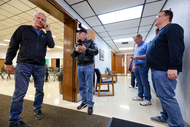 Officials of UAW Local 160 check their phones to get updates on the UAW-GM contract ratification vote count on Oct. 25, 2019 