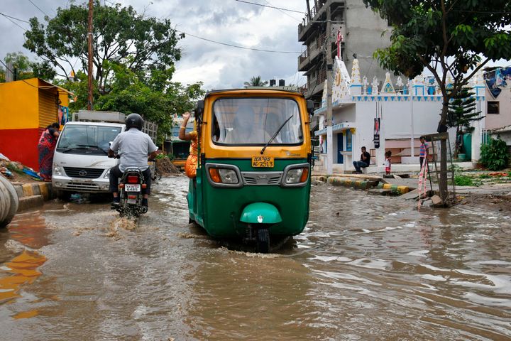 An auto-rickshaw wades through a flooded street in Bangalore after rain showers on October 24, 2019.