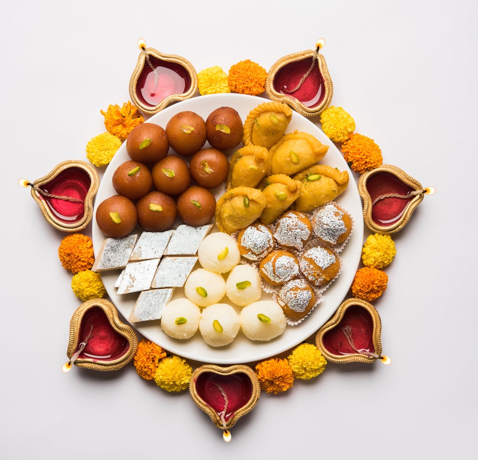 Plate full of gulab jamun, rasgulla, kaju katli, motichoor/bundi laddu, gujiya or karanji.