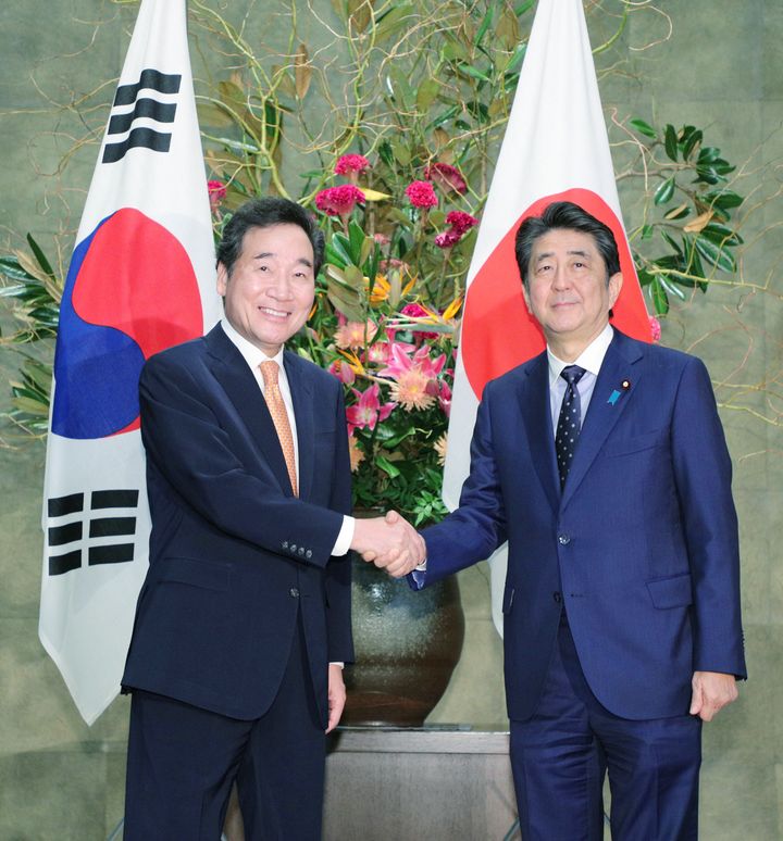 韓国の李洛淵首相（左）と握手する安倍晋三首相。会談の中で、安倍首相は韓国大法院の判決を「国際法に明確に違反」などと述べた＝10月24日、首相官邸