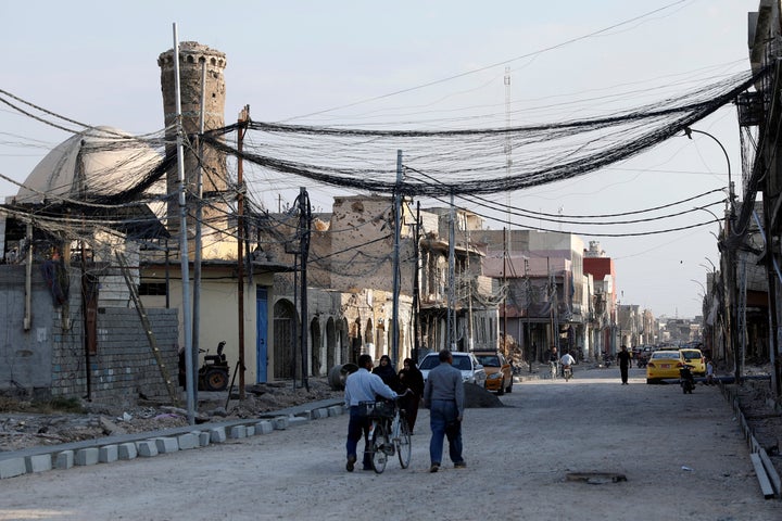 People walk on the street, where Islamic State leader Abu Bakr al-Baghdadi declared his caliphate back in 2014, in the old city of Mosul, Iraq, October 27, 2019. REUTERS/Abdullah Rashid