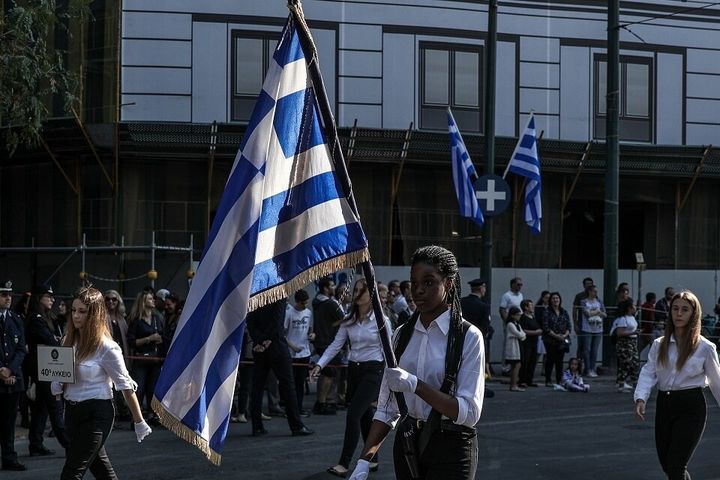 Μαθήτρια του 40ου Λυκείου Αθηνών κρατάει γεμάτη υπερηφάνεια την ελληνική σημαία.