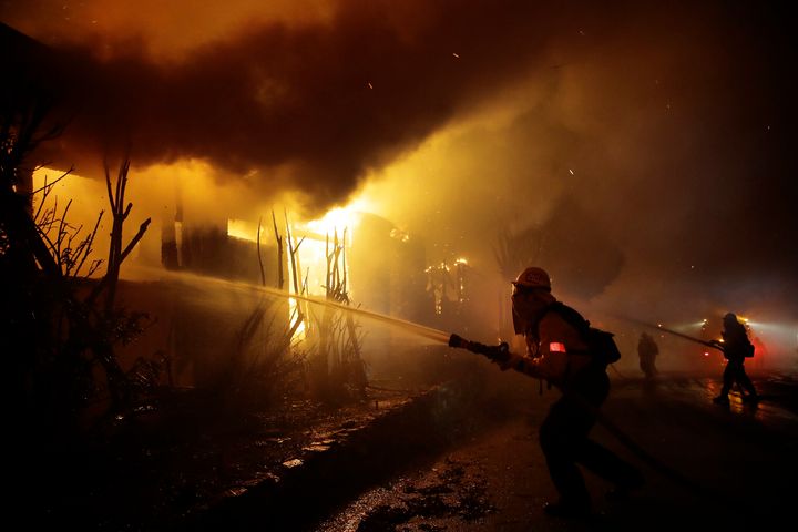 Firefighters try to salvage homes Monday as the Getty fire spreads in West Los Angeles.