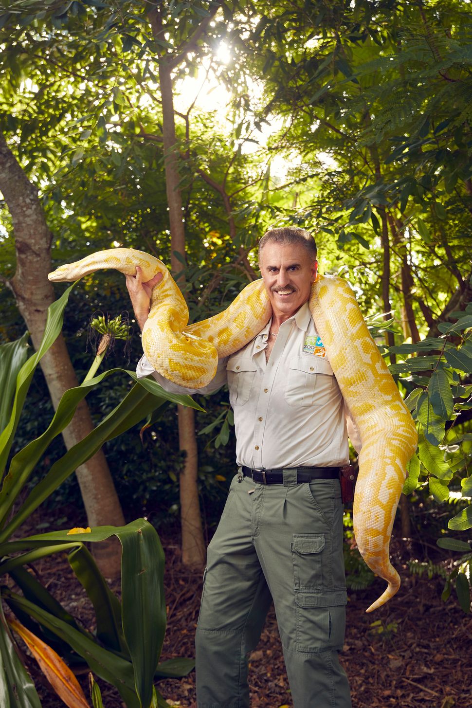 Ron Magill, goodwill ambassador at Zoo Miami, poses with an 11-foot albino Burmese python named Prince.