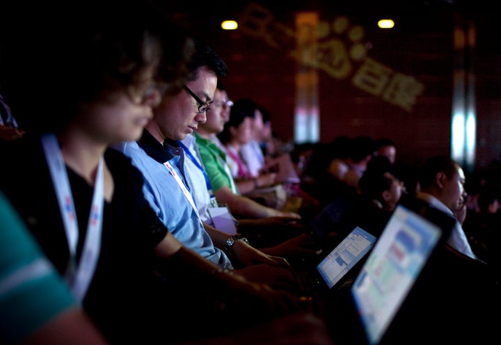 Convention participants use their laptops during a technology innovation conference held by Baidu Inc., which operates China's dominant search engine.