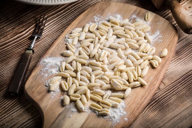 Cavatelli pasta on wooden cutting board. 