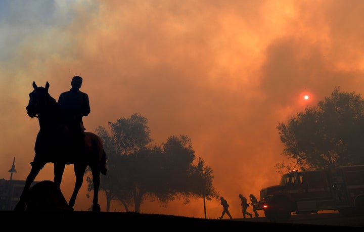 The Easy fire makes a threatening backdrop for a statue of former President Ronald Reagan outside the Reagan Presidential Library on Wednesday.