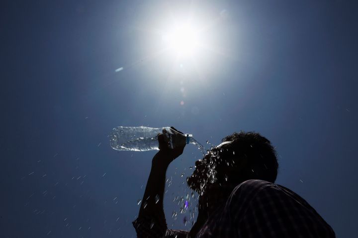 In this file photo from May 24, 2015, a man pours water on his face during a hot summer day in Hyderabad, India. Soaring temperatures caused over 2,000 deaths during the heat wave in India. 