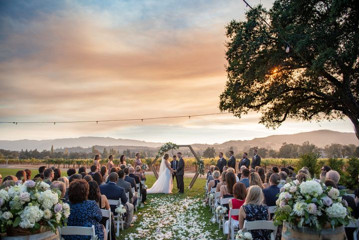 The couple’s ceremony backed by a smoky sunset.