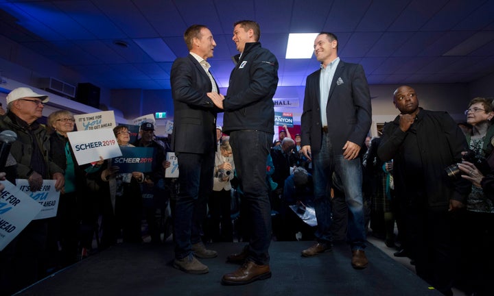 Local conservative candidate George Canyon, right, looks on as Conservative Leader Andrew Scheer, centre, shakes hands with Peter MacKay during a campaign stop in Little Harbour, N.S. on Oct. 17, 2019.