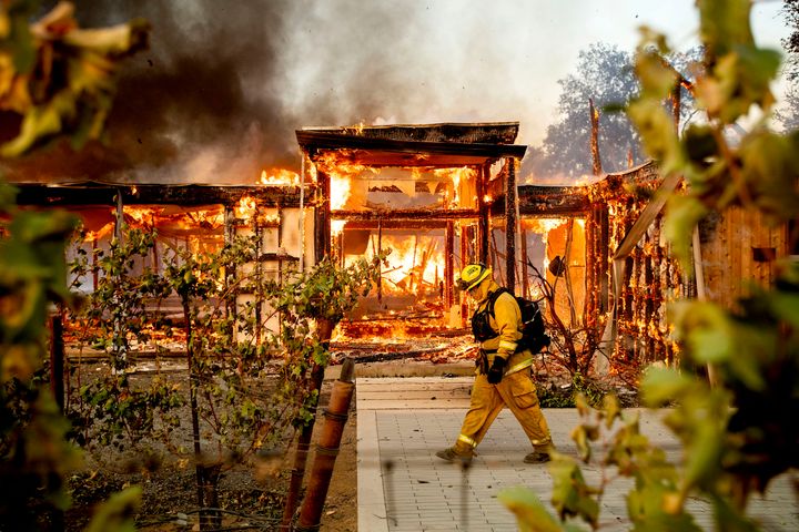 Woodbridge firefighter Joe Zurilgen passes a burning home as the Kincade Fire rages in Healdsburg, Calif., on Oct 27, 2019.