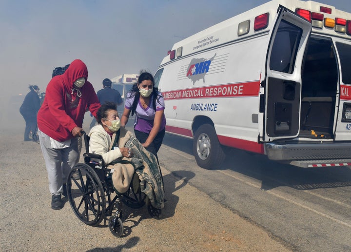 Elderly residents of the Riverside Heights Healthcare Center in Jurupa Valley, Calif., are evacuated from their care facility as flames and smoke from the Hill Fire approach on Wednesday, Oct 30, 2019.