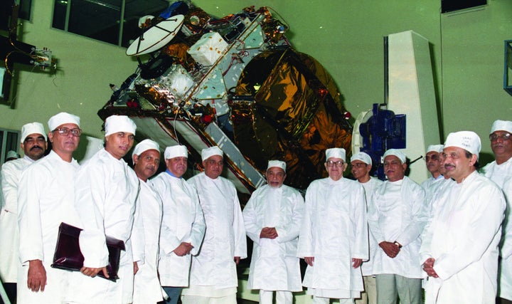 Prime Minister AB Vajpayee seen against the background of the fully integrated INSAT-2E. 