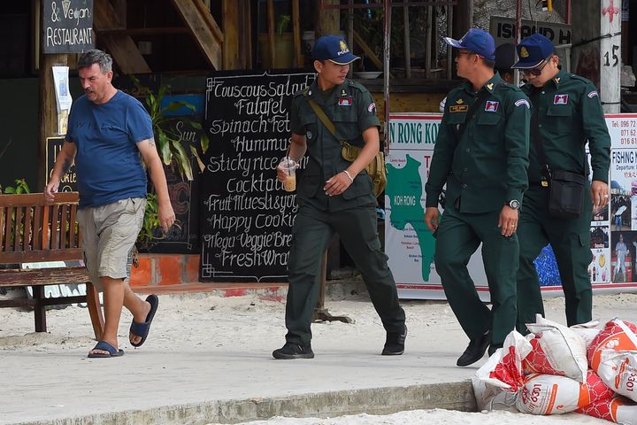 Phil Bambridge (left), the father of the missing woman walks with police officials on Koh Rong island in Sihanoukville province on October 31