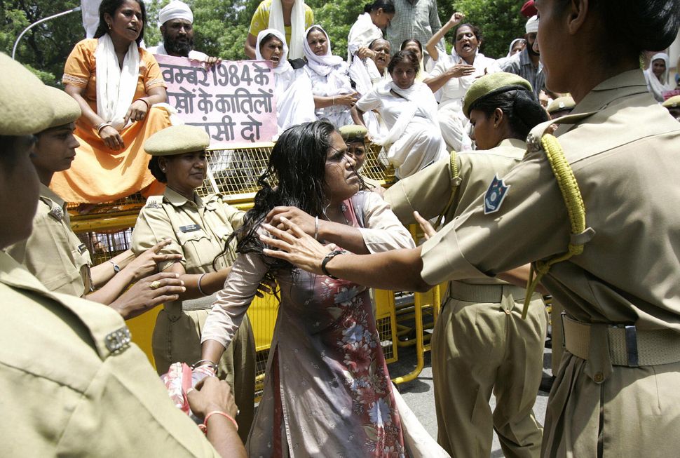 Police women tussle with widows and relatives of Sikh men who were killed in the 1984 pogrom during a demonstration in New Delhi, in August 2005, as they protest against the findings of the Nanavati Commission. 