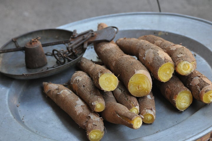 A close-up of yams, which can be white, yellow, pink or purple on the inside, with a bark-like exterior.