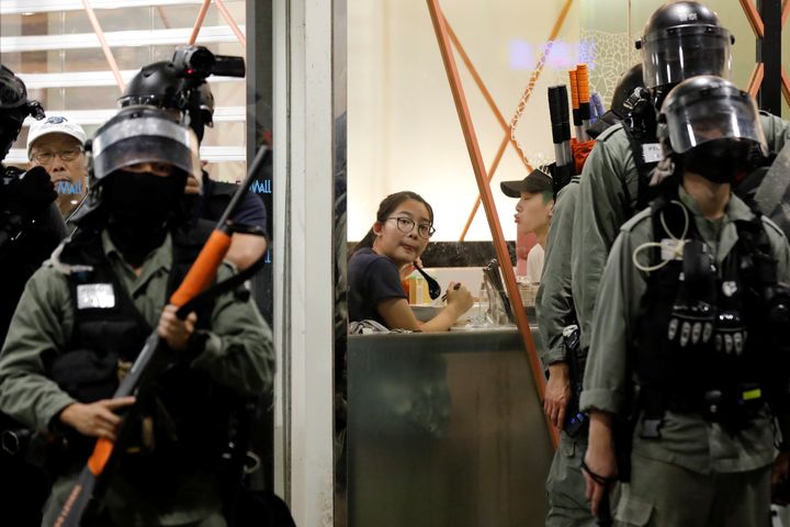 People sit inside a restaurant as riot police members stand outside a shopping mall in Tai Po in Hong Kong, China November 3, 2019. REUTERS/Kim Kyung-Hoon