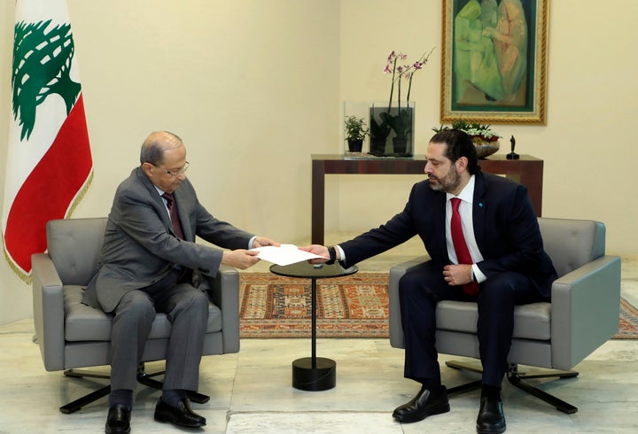 Lebanese President Michel Aoun, left, receives a letter of resignation from Prime Minister Saad Hariri, at the presidential p