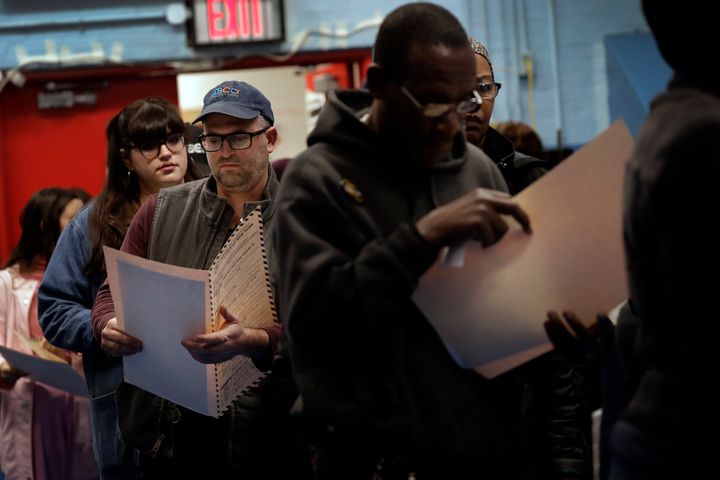In this Nov. 6, 2018 file photo, voters read their ballot papers as they wait in line to cast their vote at P.S. 161 in Brooklyn borough of New York.