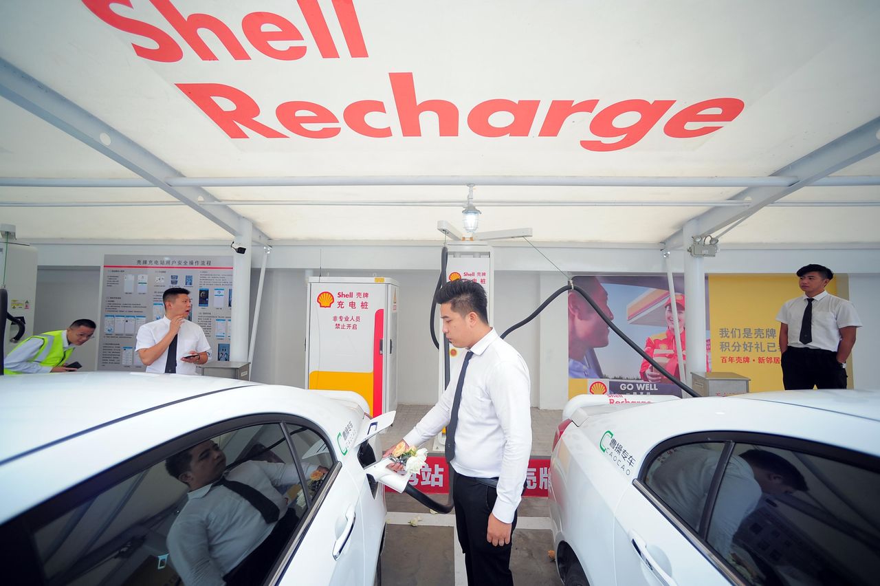 A worker charges an electric car at a Shell charging station on September 28, 2018 in Tianjin, China. 
