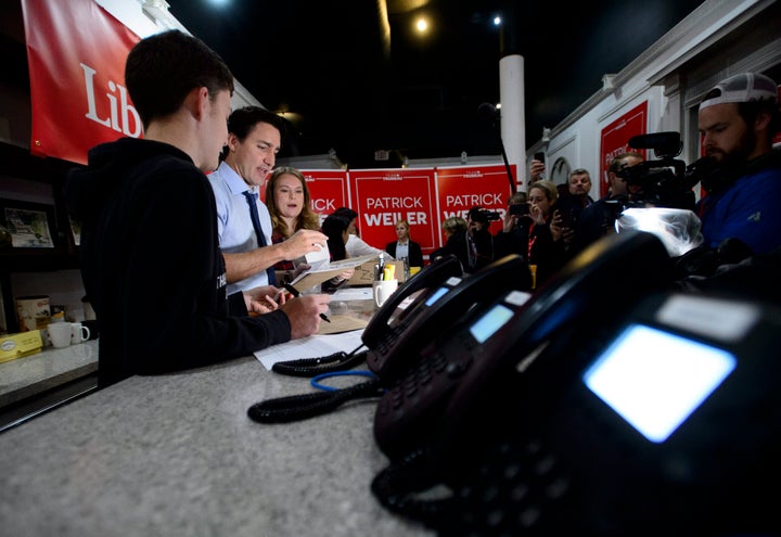 Liberal Leader Justin Trudeau works with volunteers Nicola Cox and Christian Gomes as he makes a campaign stop at a riding office in West Vancouver, B.C. on Oct. 20, 2019.