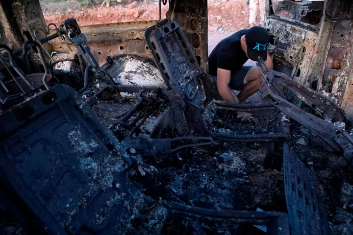 A family member looks at a car that was ambushed and burned by a drug cartel in the Sonora mountains, Mexico, on Nov. 5, 2019.