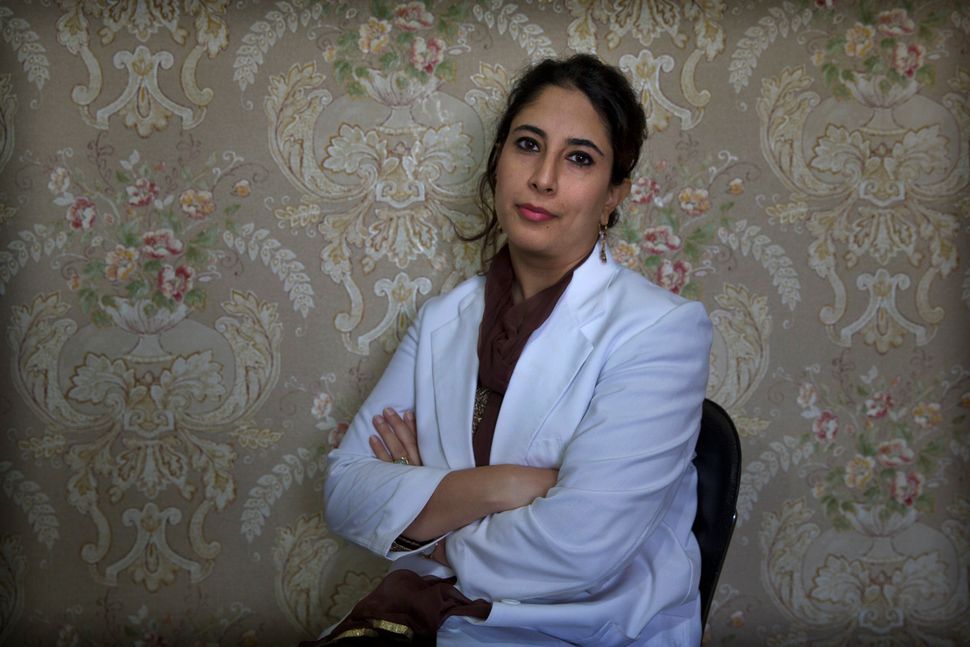 In this Sept. 27, 2019, photo, a Kashmiri doctor Sabahat Rasool sits for a photograph inside her clinic in Srinagar. 