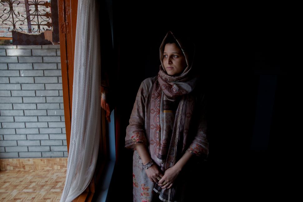 In this Oct. 14, 2019, photo, newly married Kulsuma Rameez, 24, stands for photographs inside her home on the outskirts of Srinagar. Kulsuma says she was unable to shop for her wedding and borrowed her wedding dress from a relative. Her ceremony was small, attended by a few relatives and next-door neighbours. 