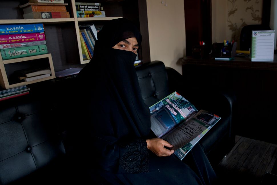 In this Wednesday, Sept. 25, 2019, photo, Sahana Fatima, the first female entrepreneur in printing who runs the only sports magazine in the Kashmir valley, sits for a photograph inside her office in Srinagar. Fatima says they were unable to print the August edition due to the blockade. “Even if we had decided to print, what would we write about? There was nothing happening as far as sports activities were concerned. Everything has come to a standstill.” 