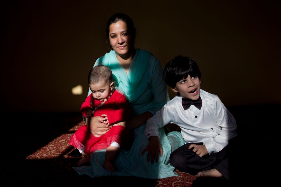 In this Oct. 14, 2019, photo, a Kashmiri-born Australian Sumaya Rather sits with her eight-month-old daughter Noor Rather and four-year-old son Ahmed Rather inside her maternal home on the outskirts of Srinagar. Sumaya said Noor fell ill because she couldn’t adjust to the milk supplement brands that were available in Srinagar. Taking her to a hospital was a big challenge as there were protests and road blockades set up by both soldiers and Kashmiri youths. 