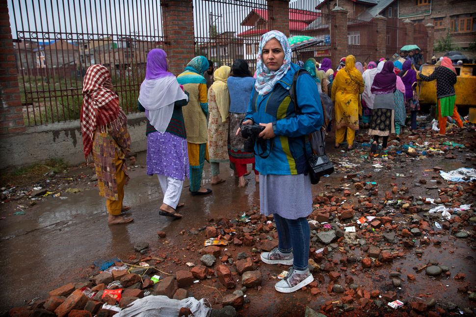In this Oct. 4, 2019. photo, Kashmiri photojournalist Masrat Zahra stands for a photograph during a protest on the outskirts of Srinagar. ‘I’ll kick you with my boots and take you to the governor’s house,’ a policeman told Zahra as she covered the first Friday protest since the Aug. 5 lockdown. “Women cannot move out of their homes without a male companion for fear of harassment,” she says. But adds “you cannot remain silent. If you come out and speak, someone will hear your voice. Coming out to work is my way of protesting.” 