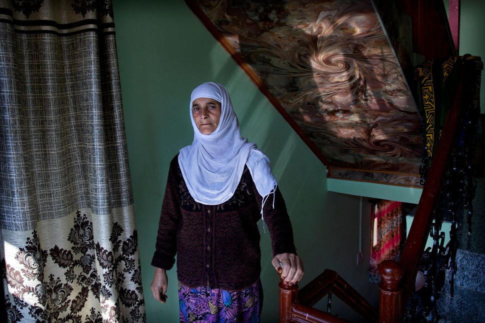 In this Friday, Oct. 14, 2019, photo, a Kashmiri woman Biba Malla stands for a photograph inside her house on the outskirts of Srinagar, Indian-controlled Kashmir. Malla's cousin died on Aug. 31, 2019, but she was informed about it almost a week later. "I missed the funeral and the 'Fateh Khani' condolence meeting, which is held on the fourth day and is very important for us. Our menfolk still haven’t visited fearing detention by police on the way to our relative's home," she said. 