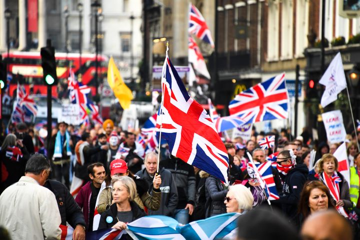 イギリス国旗やプラカードを掲げて練り歩く人たち