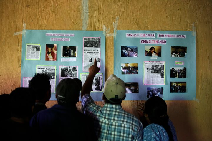 Guatemalans who were deported from the U.S. after a 2008 immigration raid in Postville, Iowa, and ended up in San Jose Calderas in Central Guatemala look at news clippings about the raid on May 12, 2009.