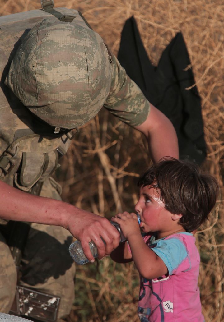 14 Ιούνιου 2015 - Τούρκος στρατιώτης προσφέρει νερό σε ένα προσφυγόπουλο στην τουρκική μεθοριακή περιοχή Ακστάκαλε.