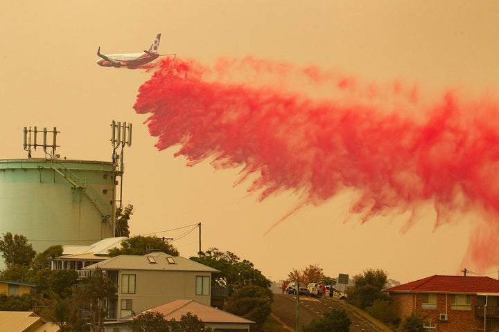 A water bombing plane drops fire retardant on a bushfire in Harrington.
