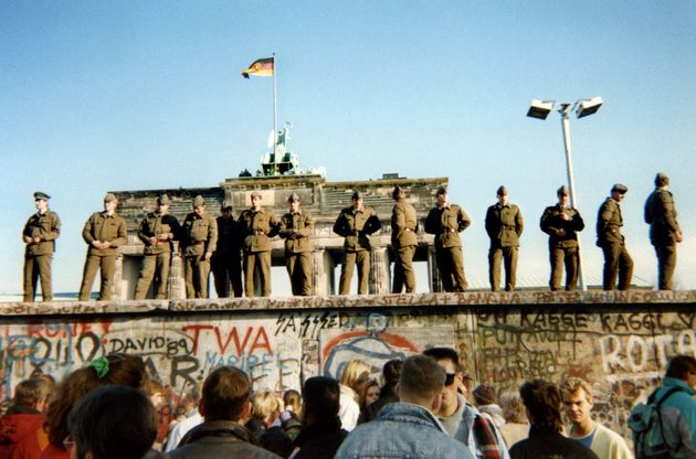 Des gardes-frontières est-allemands se tiennent debout sur une section du mur de Berlin, avec...