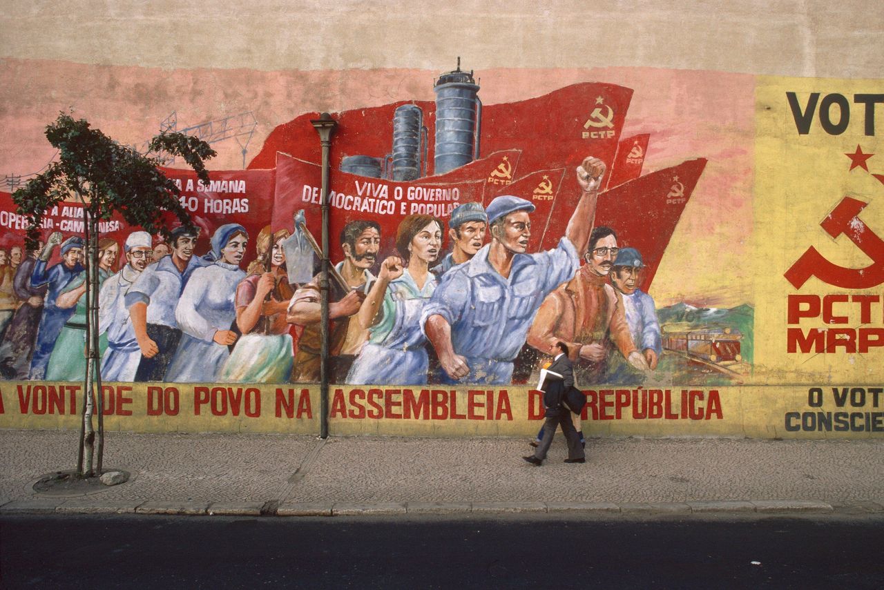 People walk by a mural evoking the Carnation Revolution in Lisbon, Portugal on Jan. 1, 2000. 