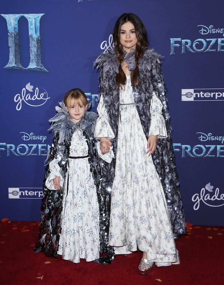 A full-length view of the sisters' matching outfits.