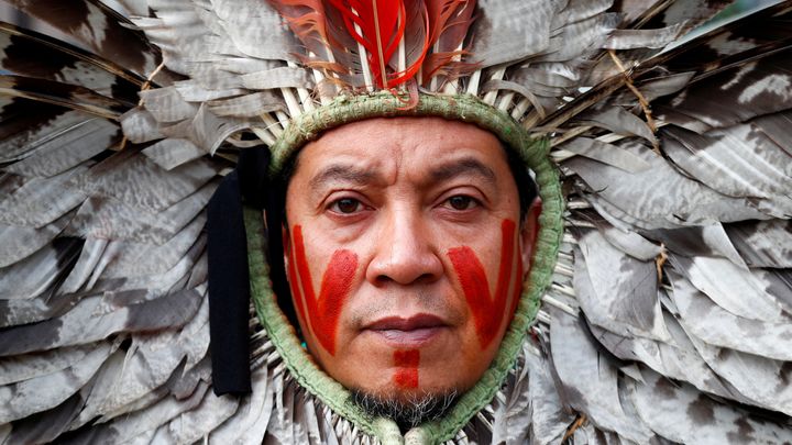Ένας ηγέτης της τοπικής κοινότητας της Βραζιλίας συμμετέχει σε διαμαρτυρία κατά της καταστροφής του δάσους του Αμαζονίου, έξω από την έδρα της Ευρωπαϊκής Επιτροπής, στις Βρυξέλλες στις 5 Νοεμβρίου 2019. (Credit: Francois Lenoir / Reuters.)