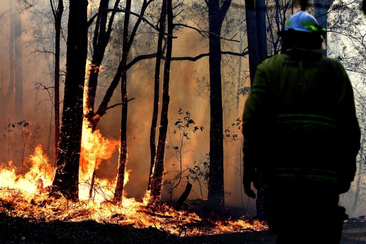 A firefighter works as a bushfire, believed to have been sparked by a lightning strike that has ravaged an area of over 2,000 hectares in northern New South Wales state, burns in Port Macquarie. 