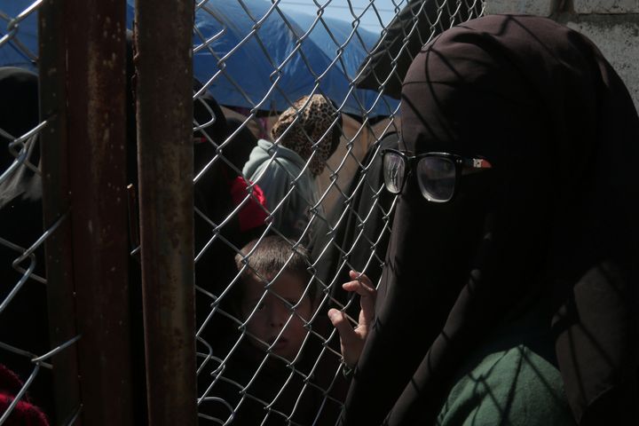 A woman looks through a chain linked fence at al-Hol displacement camp in Hasaka governorate, Syria March 8, 2019. REUTERS/Issam Abdallah