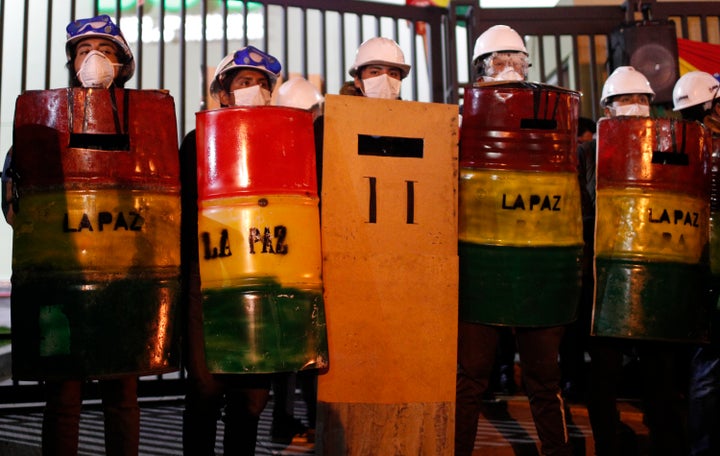 Demonstrators with makeshift shields protest against President Evo Morales' reelection, in La Paz, Bolivia, Saturday, Nov. 9, 2019. 